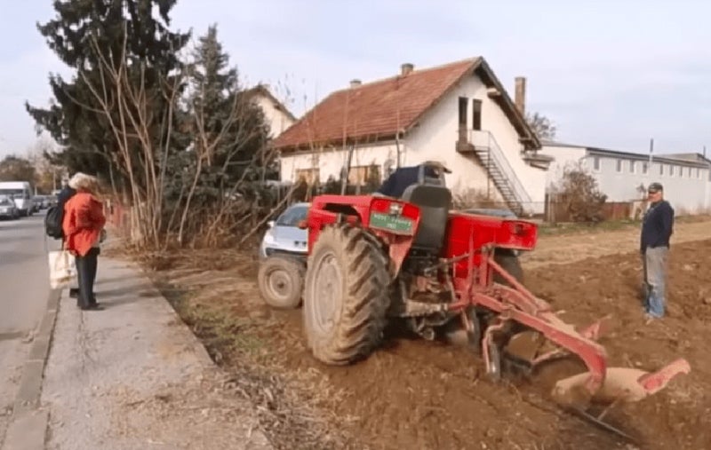 Roter Traktor an Land
